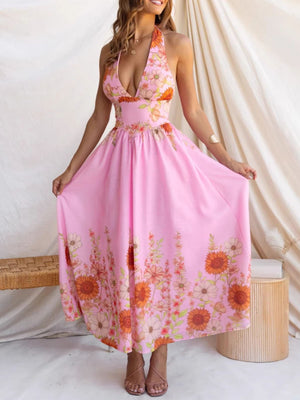 Pink floral halter neck maxi dress with deep V-neck and flowing skirt.