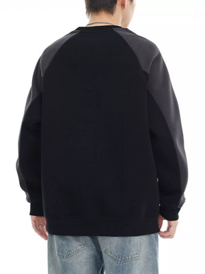 Black oversized sweatshirt with raglan sleeves and contrasting gray panels.