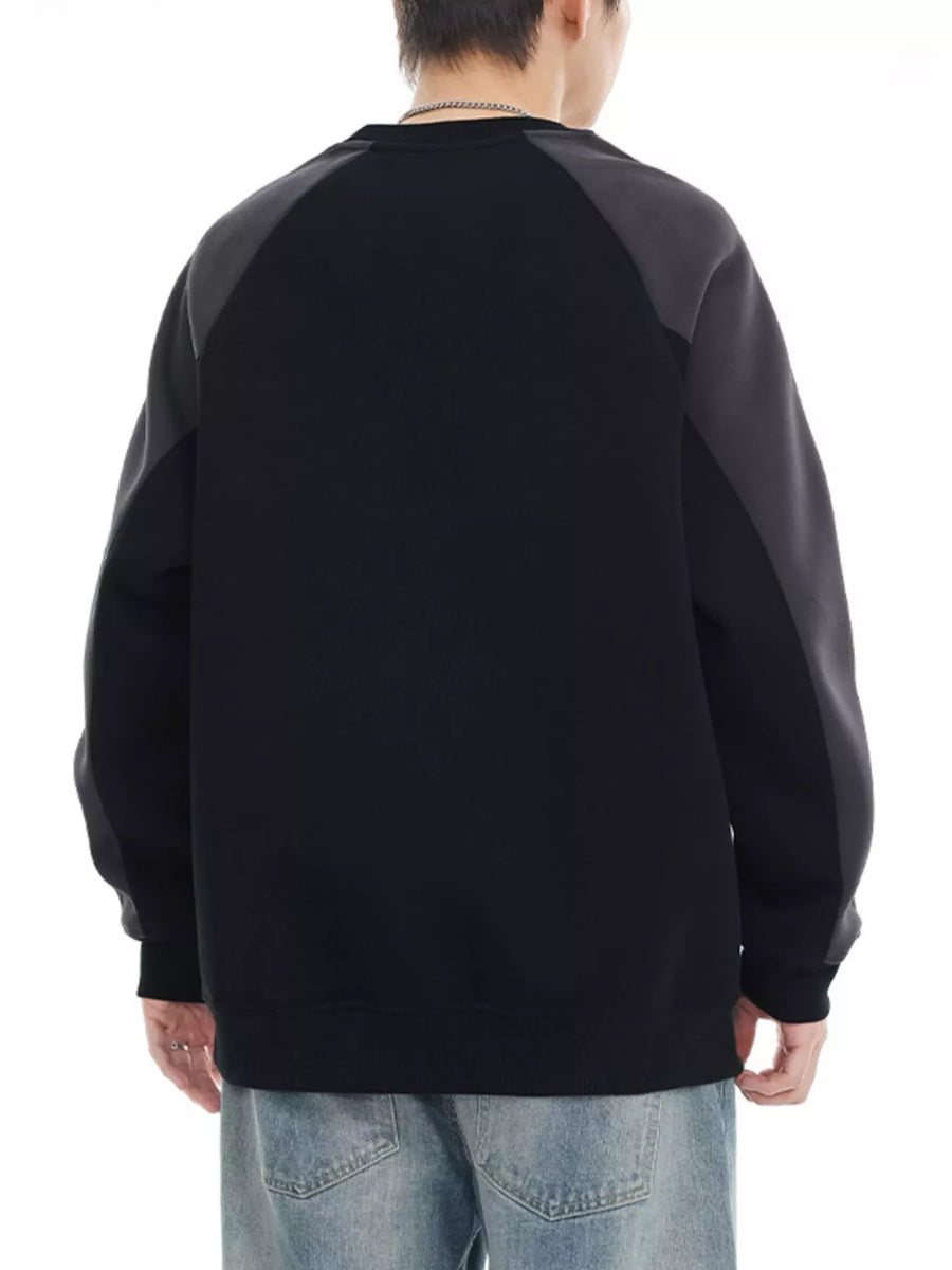Black oversized sweatshirt with raglan sleeves and contrasting gray panels.