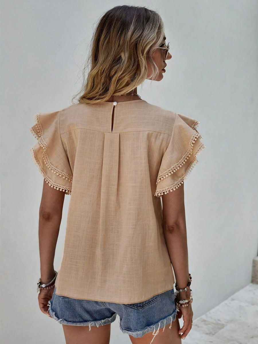 Khaki blouse with ruffle sleeves trimmed with pom-poms and a keyhole back detail.