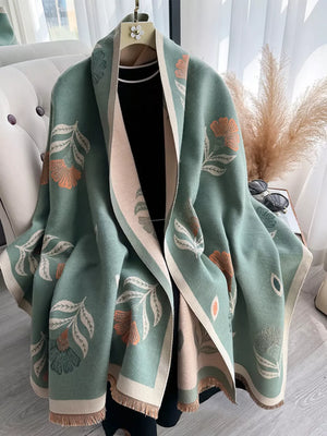 Green floral print fringed shawl with beige trim, styled open over a black top.