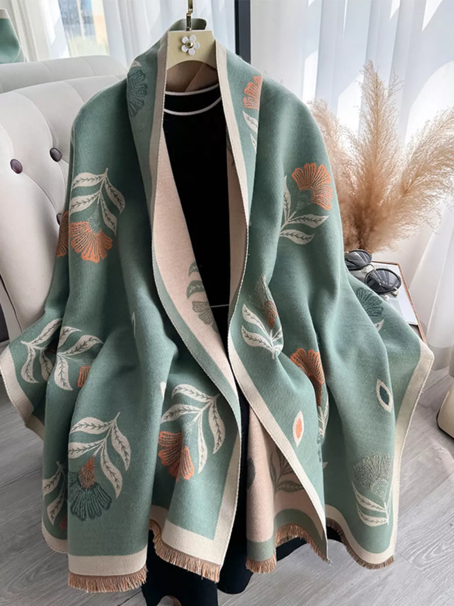 Green floral print fringed shawl with beige trim, styled open over a black top.