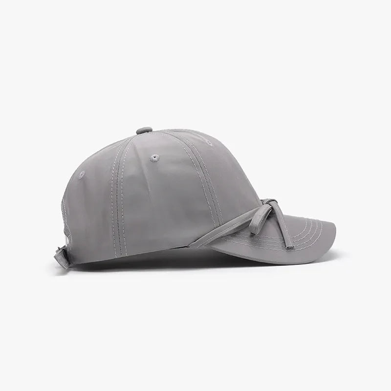 Gray baseball cap with tied-back detail and breathable fabric.