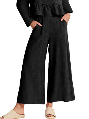Black wide-leg pants with pockets and a ruffled hem top, part of a two-piece set.