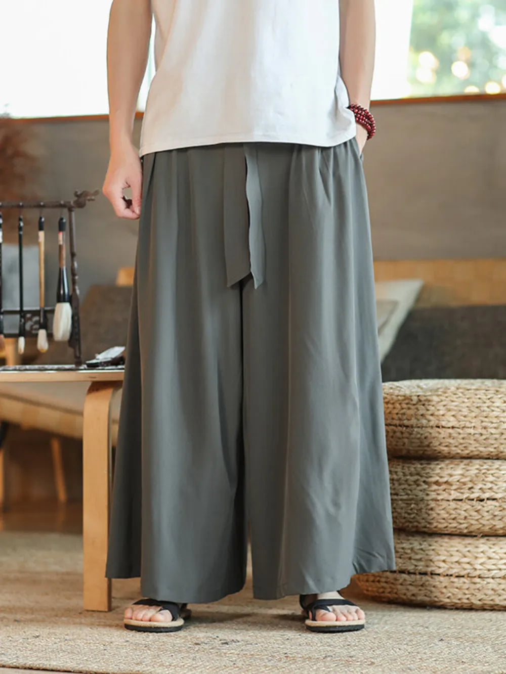 Men's grey relaxed fit sweatpants with drawstring waist and wide leg.