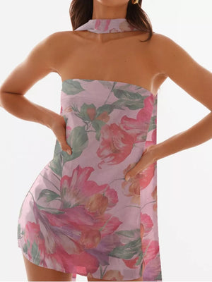 Blush pink strapless mini dress with a large floral print and halter neckline.