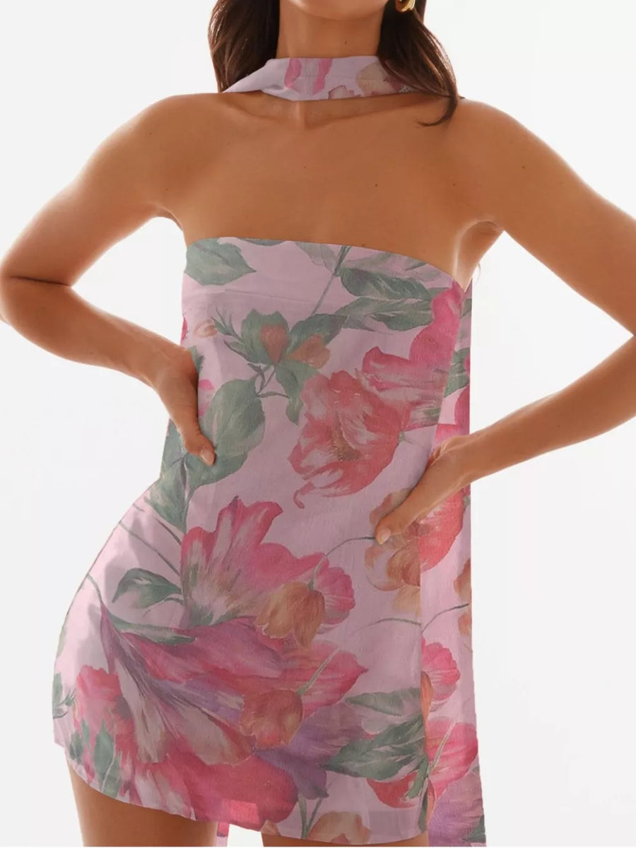 Blush pink strapless mini dress with a large floral print and halter neckline.