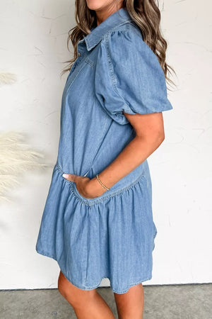 Denim dress with puff sleeves, ruffled hem, and pockets.