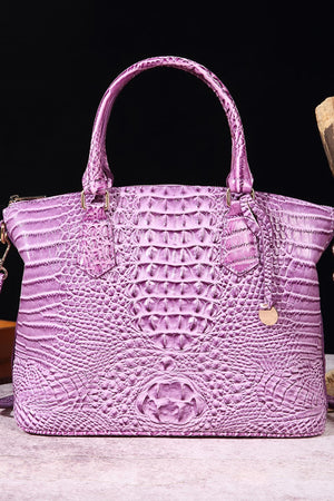 Lilac crocodile embossed satchel bag with top handles and shoulder strap.
