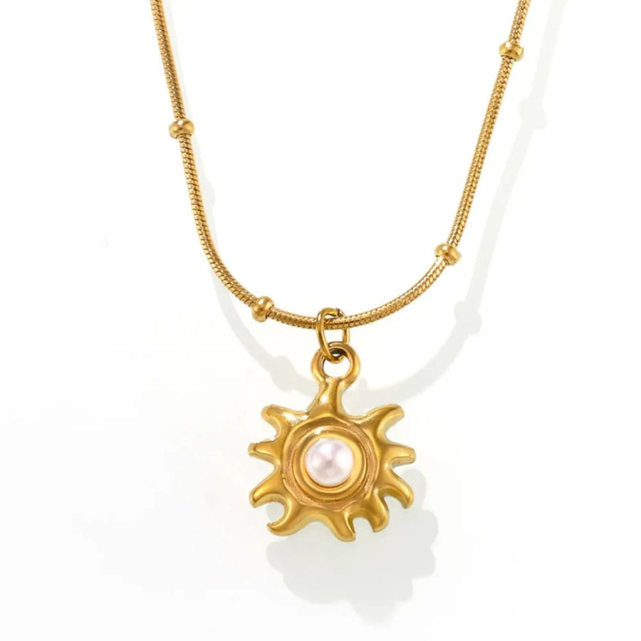 Gold sunburst pendant necklace with pearl detail on a delicate chain with beads.