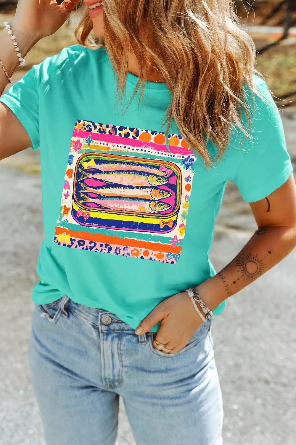 Teal cotton crew neck t-shirt with playful sardine can graphic and leopard print trim.