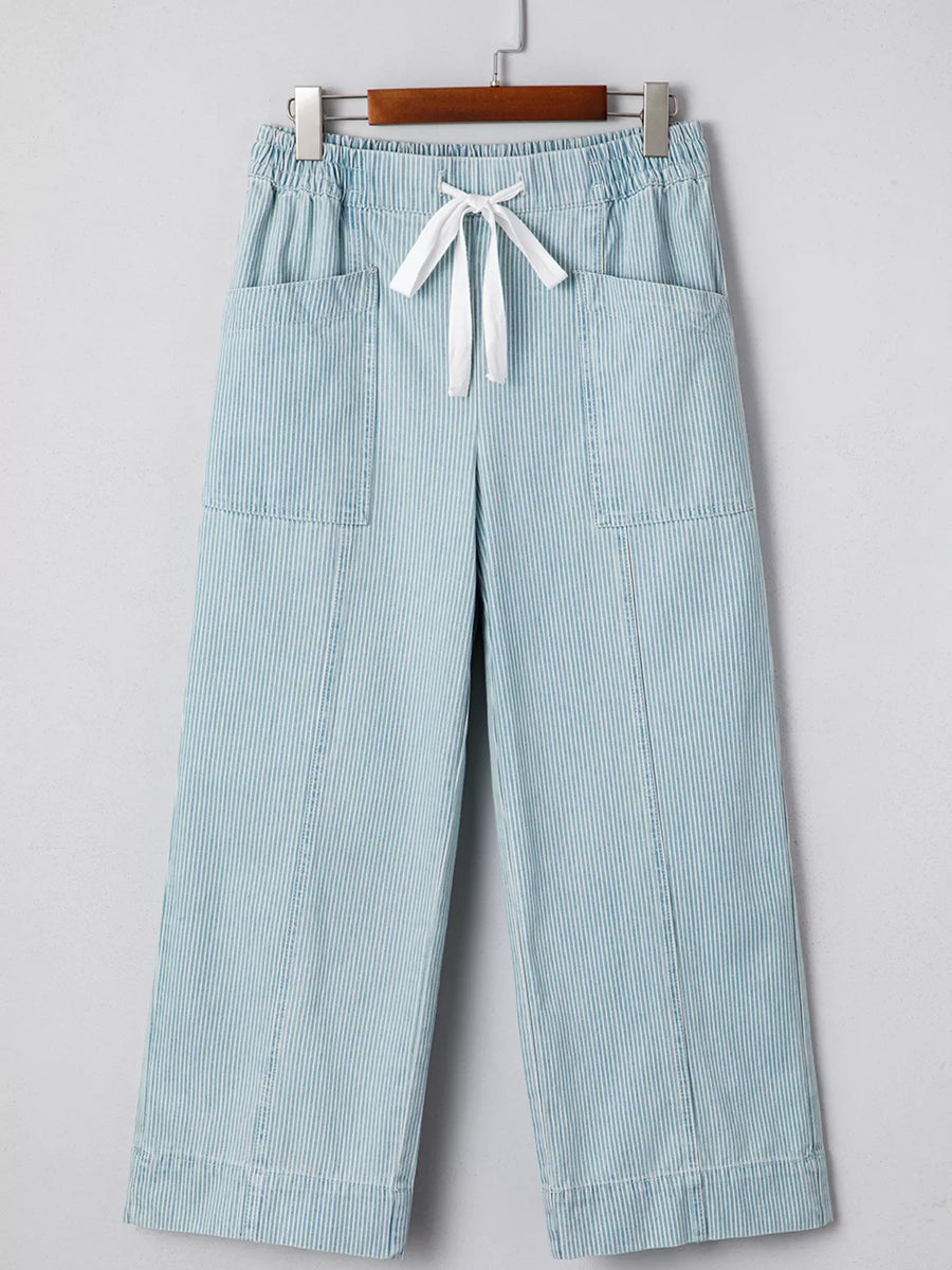 Light blue striped mid rise drawstring jeans with wide legs and front pockets.