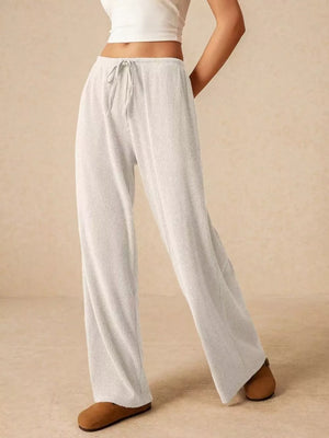 White ribbed wide-leg drawstring pants with a relaxed fit.