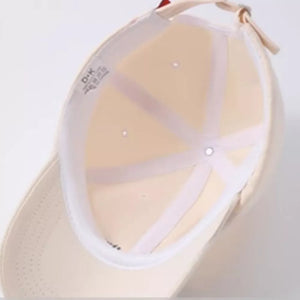 Beige cotton 6-panel baseball cap interior with embroidered text detail.