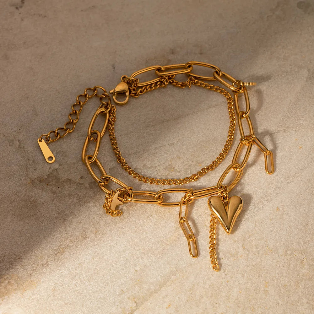 Gold layered chain bracelet with heart charm and 18K gold plating.