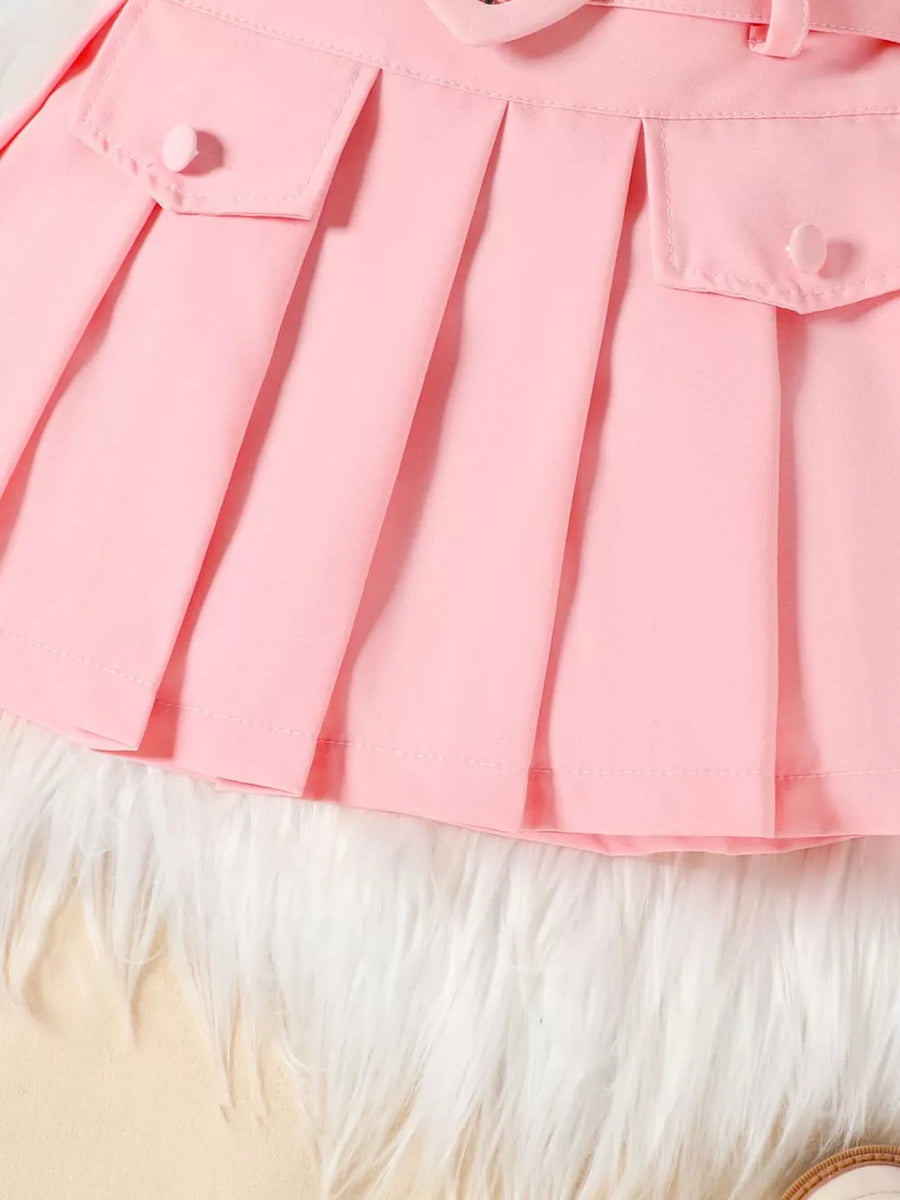 Pink baby skirt with pleats, buttoned pockets, and a bowknot belt detail.