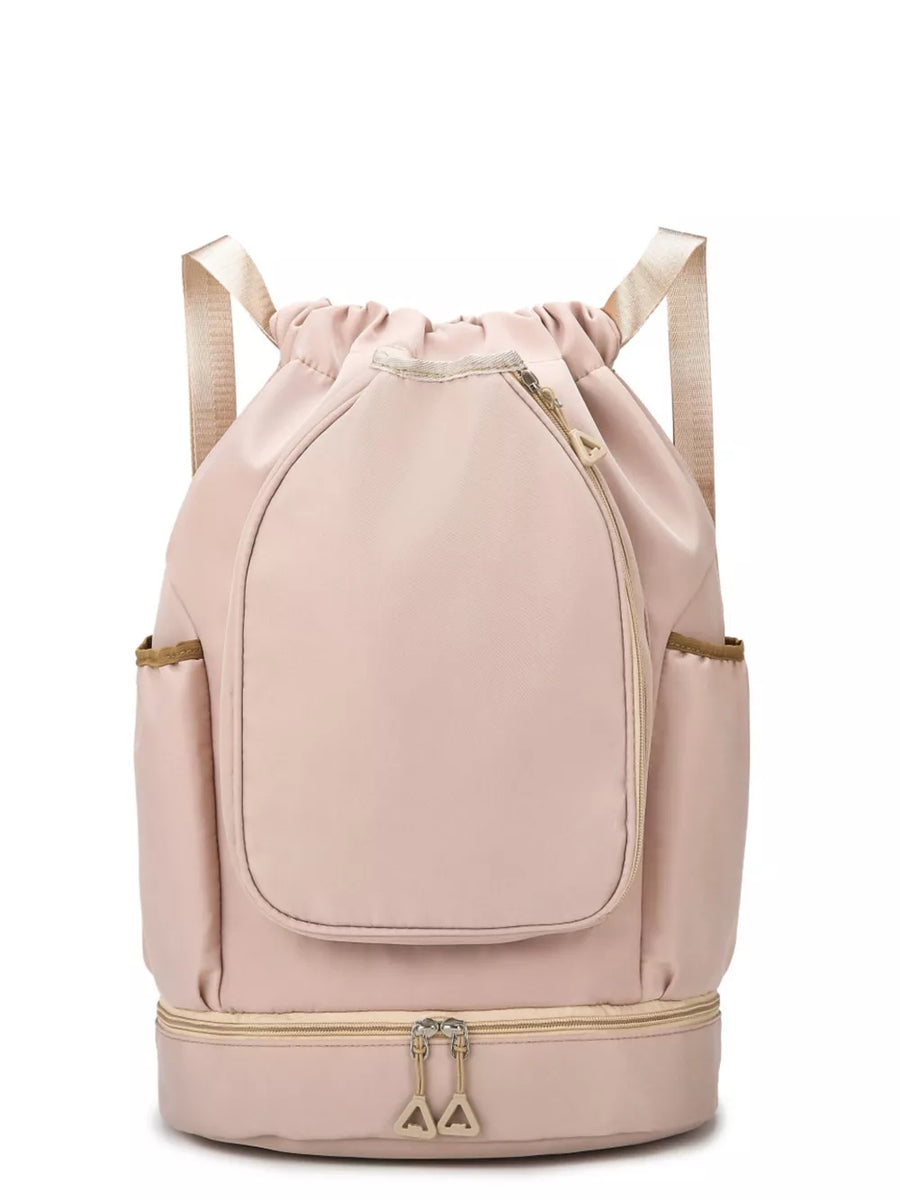Blush pink drawstring duffel bag with front zip pocket and bottom zip compartment.