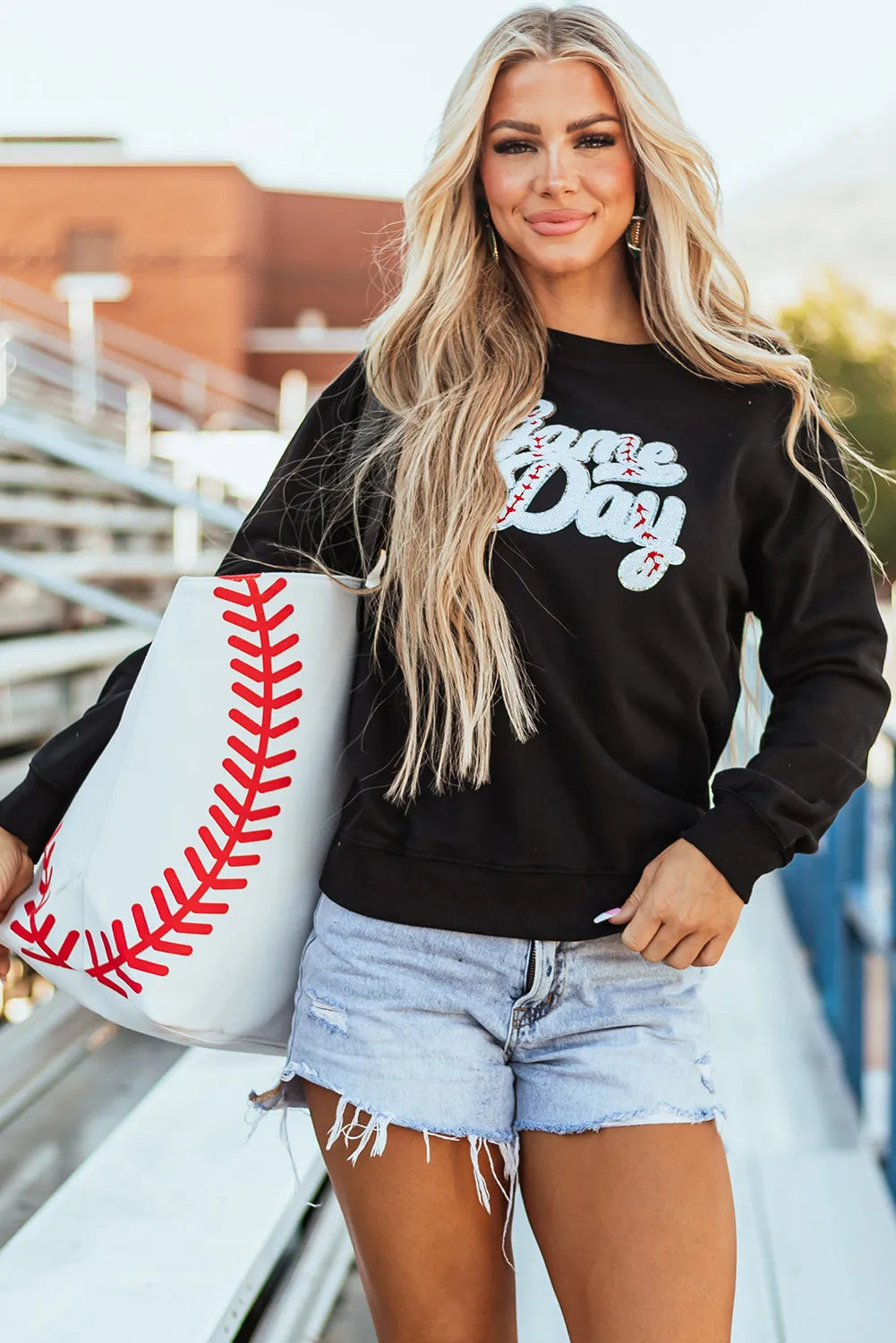 Black sweatshirt with white baseball script appliqué and red stitching detail.