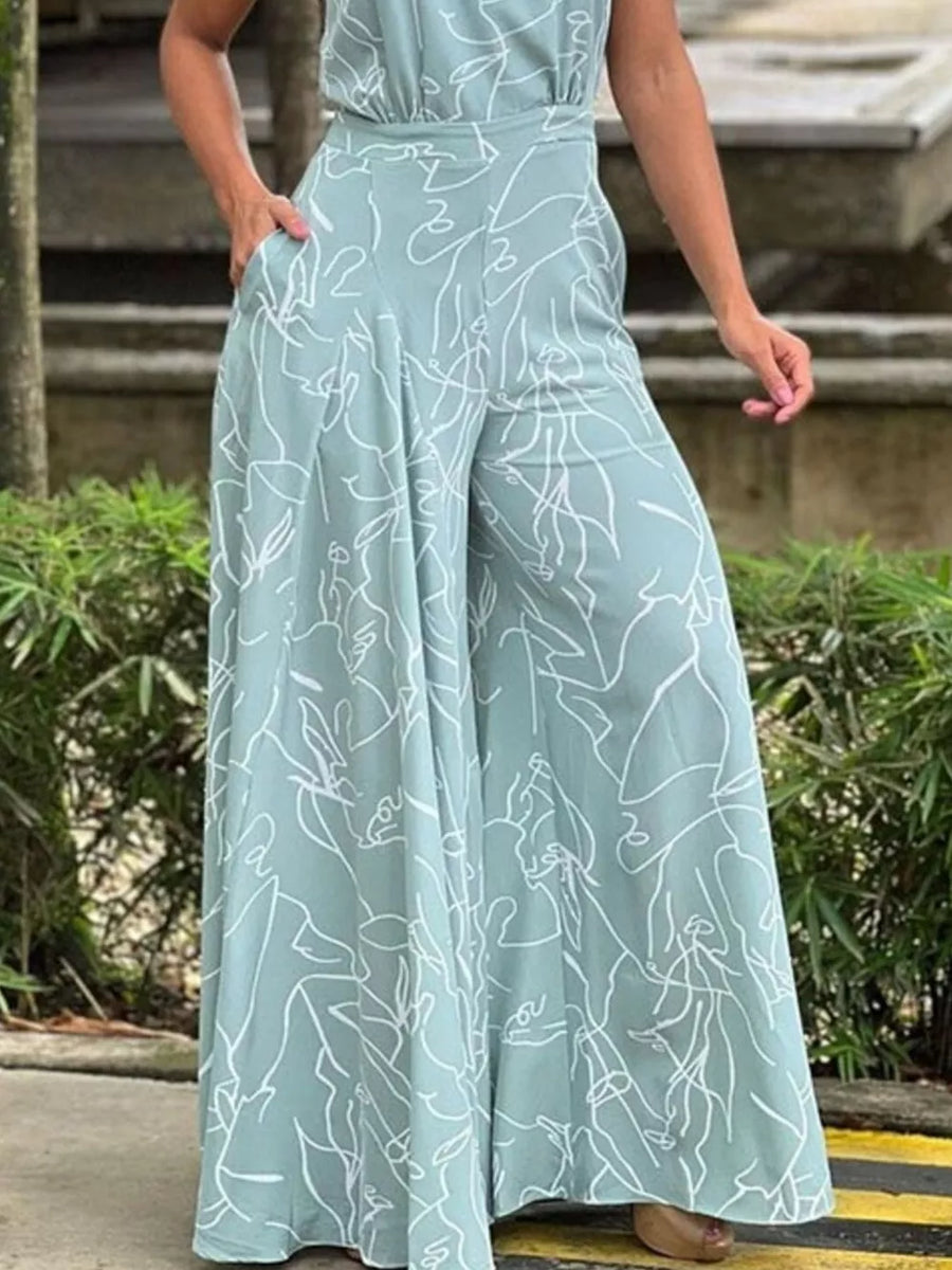 Abstract print halter neck romper in light blue with wide legs and pockets.