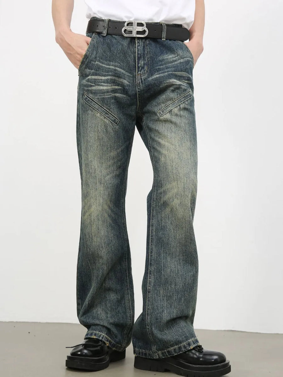 Vintage wash flare leg jeans in medium blue denim with distressed details and angled pockets.