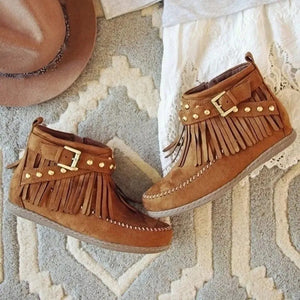 Caramel suede ankle boots with fringe and gold studs, featuring buckle detail.
