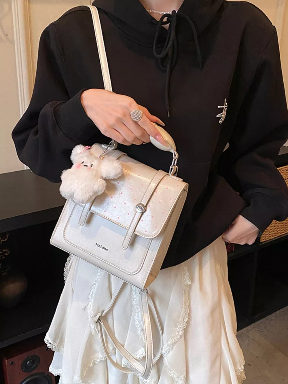 Cream White backpack featuring flap closure and polka dot