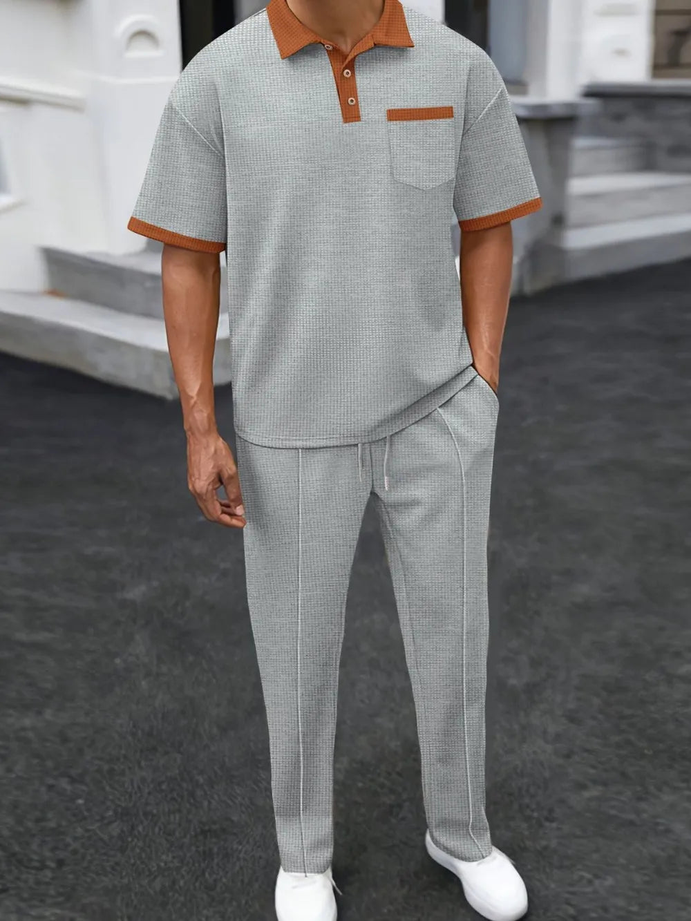 Gray textured polo shirt with contrast collar and pocket, paired with matching track pants.