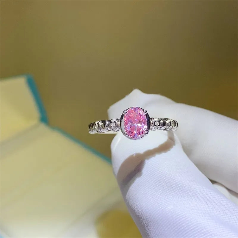 Pink oval moissanite ring in silver with beaded band detail.