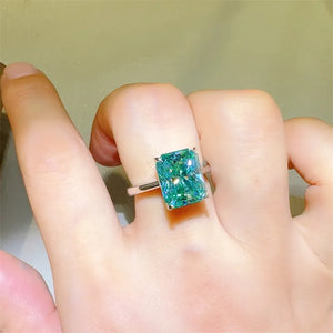 Emerald cut moissanite ring in architectural silver setting with bright brilliance.