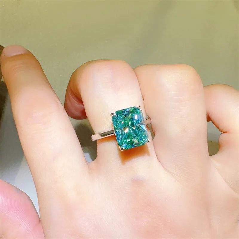 Emerald cut moissanite ring in architectural silver setting with bright brilliance.