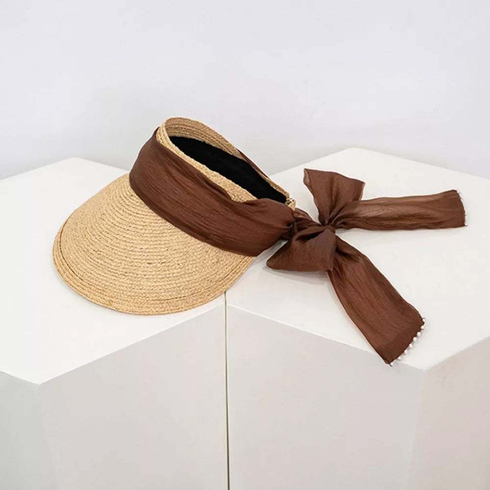 Straw visor hat in coffee color with brown ribbon tie and beaded detail