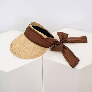 Straw visor hat in coffee color with brown ribbon tie and beaded detail