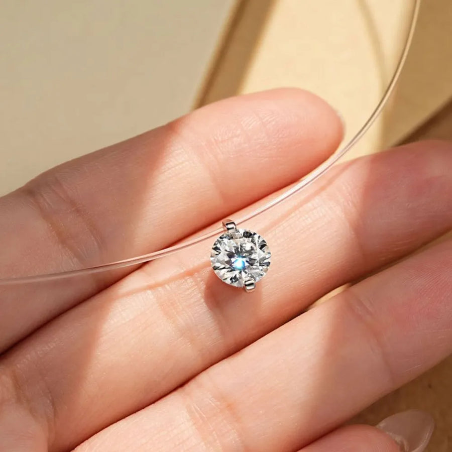Silver floating moissanite necklace with a single clear stone on a thin wire chain.