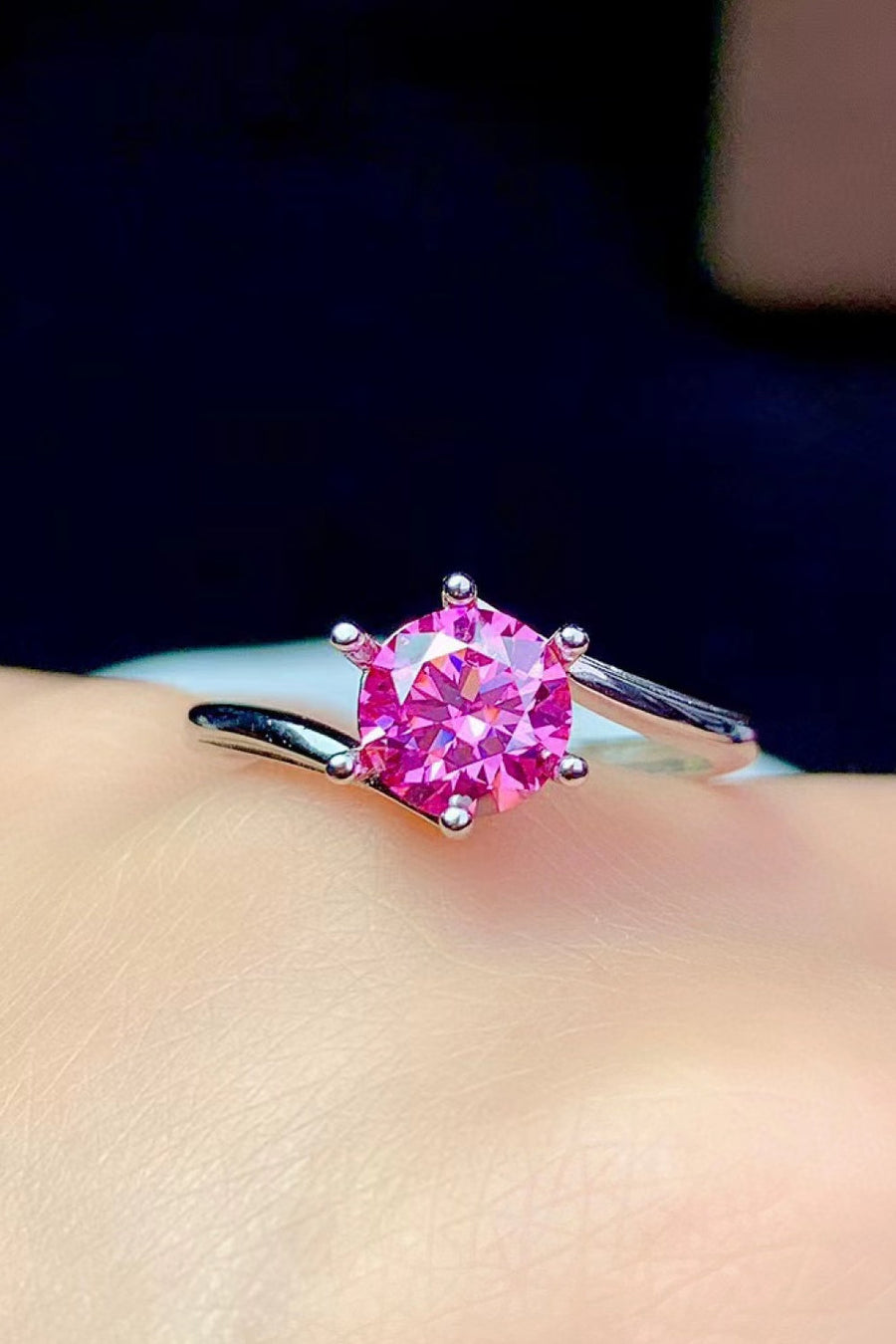 Radiant pink moissanite solitaire ring with a six-prong setting on a silver band.