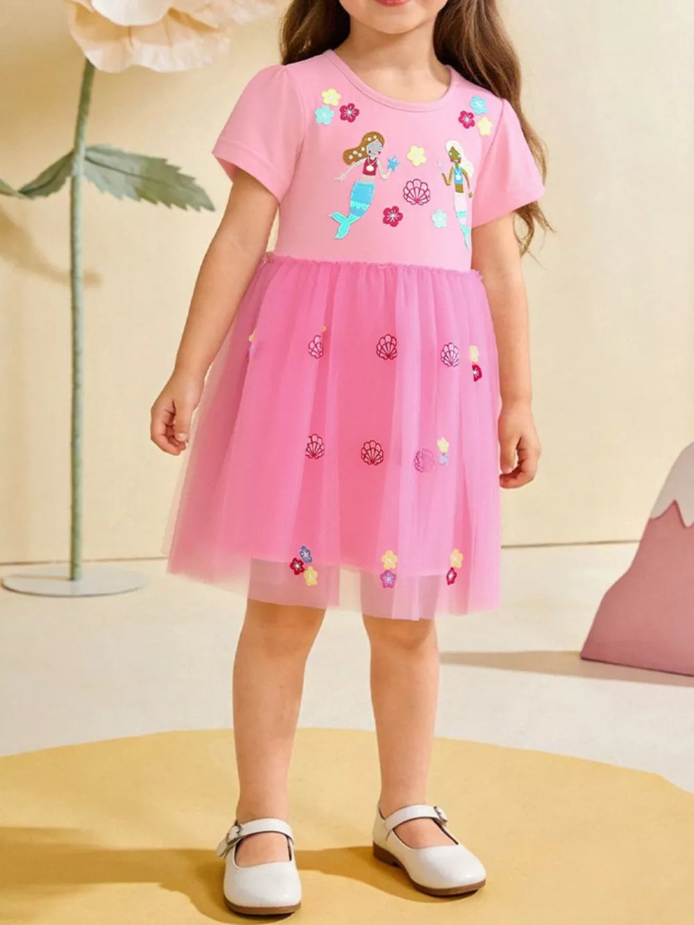 Pink tulle toddler dress with mermaid embroidery and shell accents.