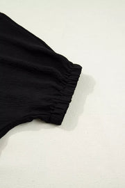 Black polyester tunic with cinched elastic cuff detail on sleeve