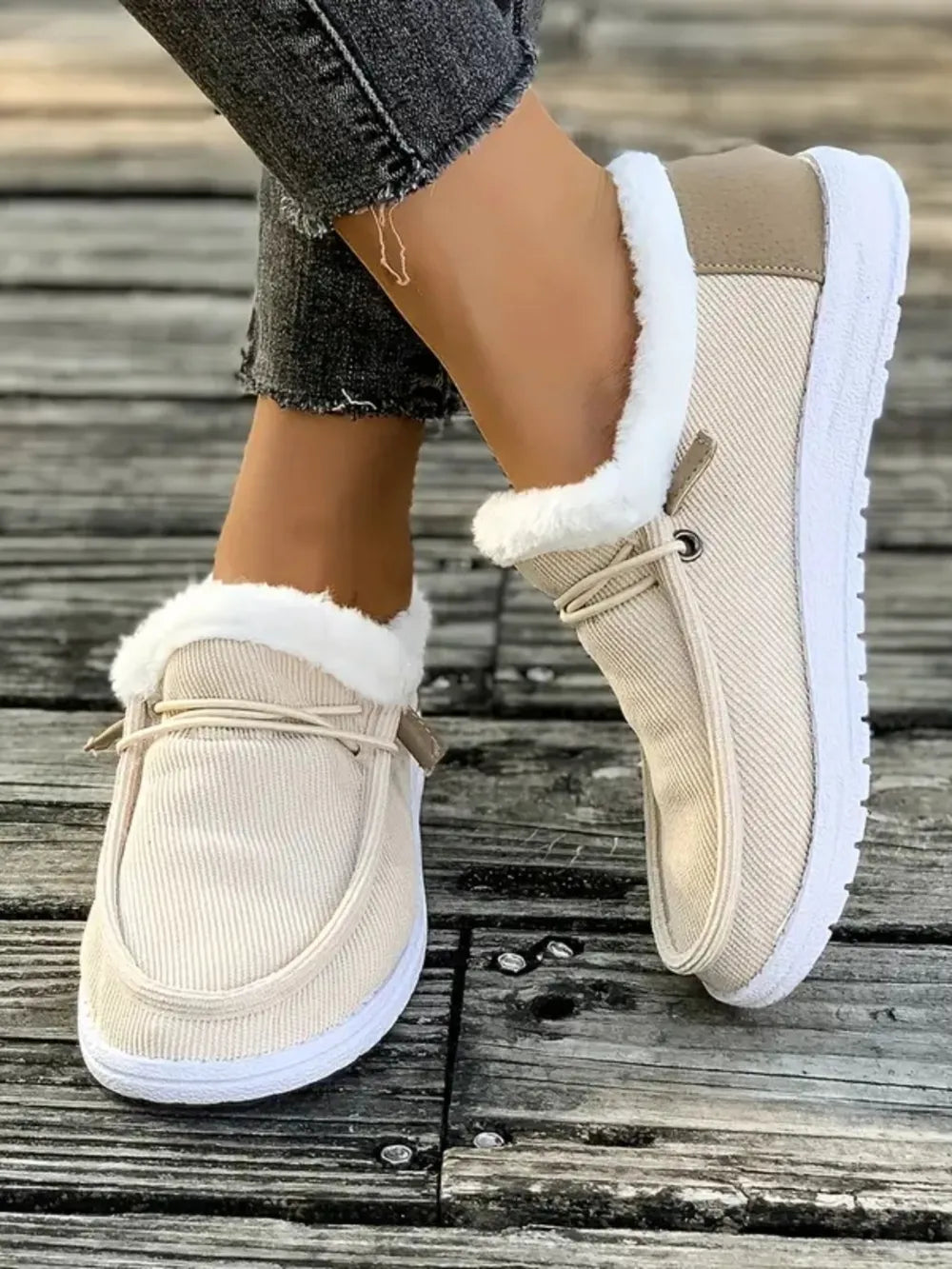 Ivory corduroy slip-on sneakers with white sherpa lining and lace detail.
