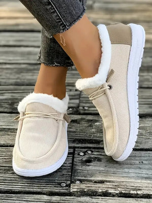 Ivory corduroy slip-on sneakers with white sherpa lining and lace detail.