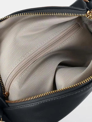 Black faux leather belt bag interior with chevron lining and gold zipper detail.