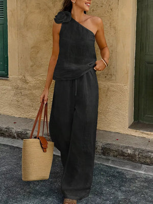 Black floral embellished one-shoulder top and wide-leg pants set with drawstring waist.