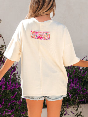 Cream cotton oversized t-shirt with floral chenille patch detail on back.