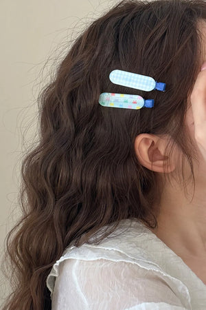 Pastel blue gingham and bunny print hair clips with blue clasps.