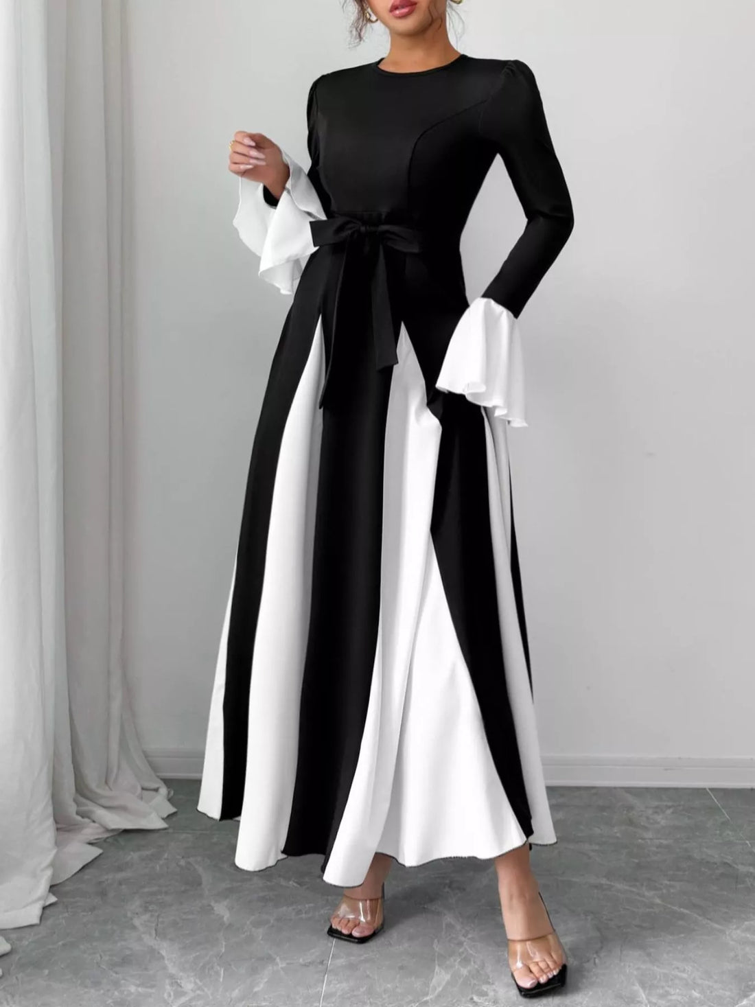 Black and white maxi dress with flare sleeves, tie waist, and striped skirt.