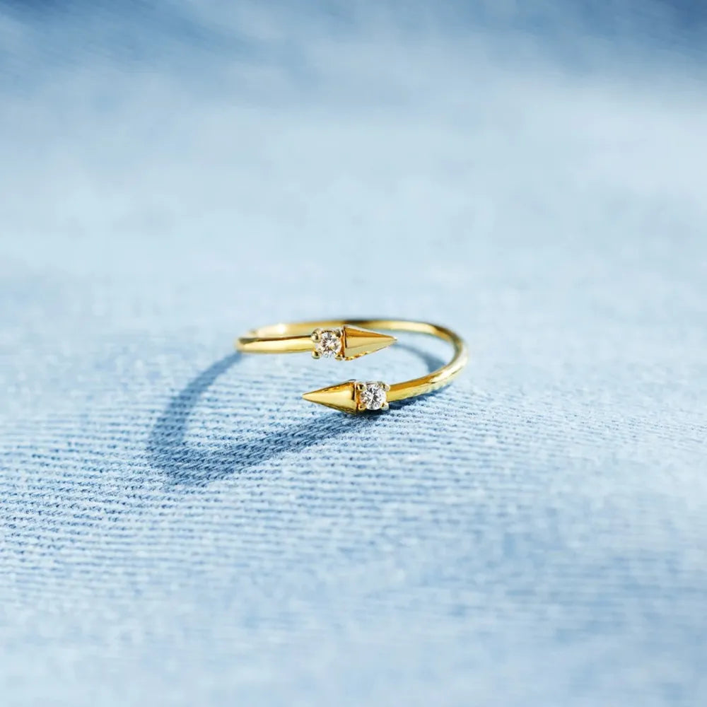 Gold bypass ring with spiked ends and cubic zirconia details