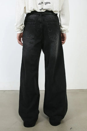 Oversized black wash denim jeans with a wide leg and distressed details.
