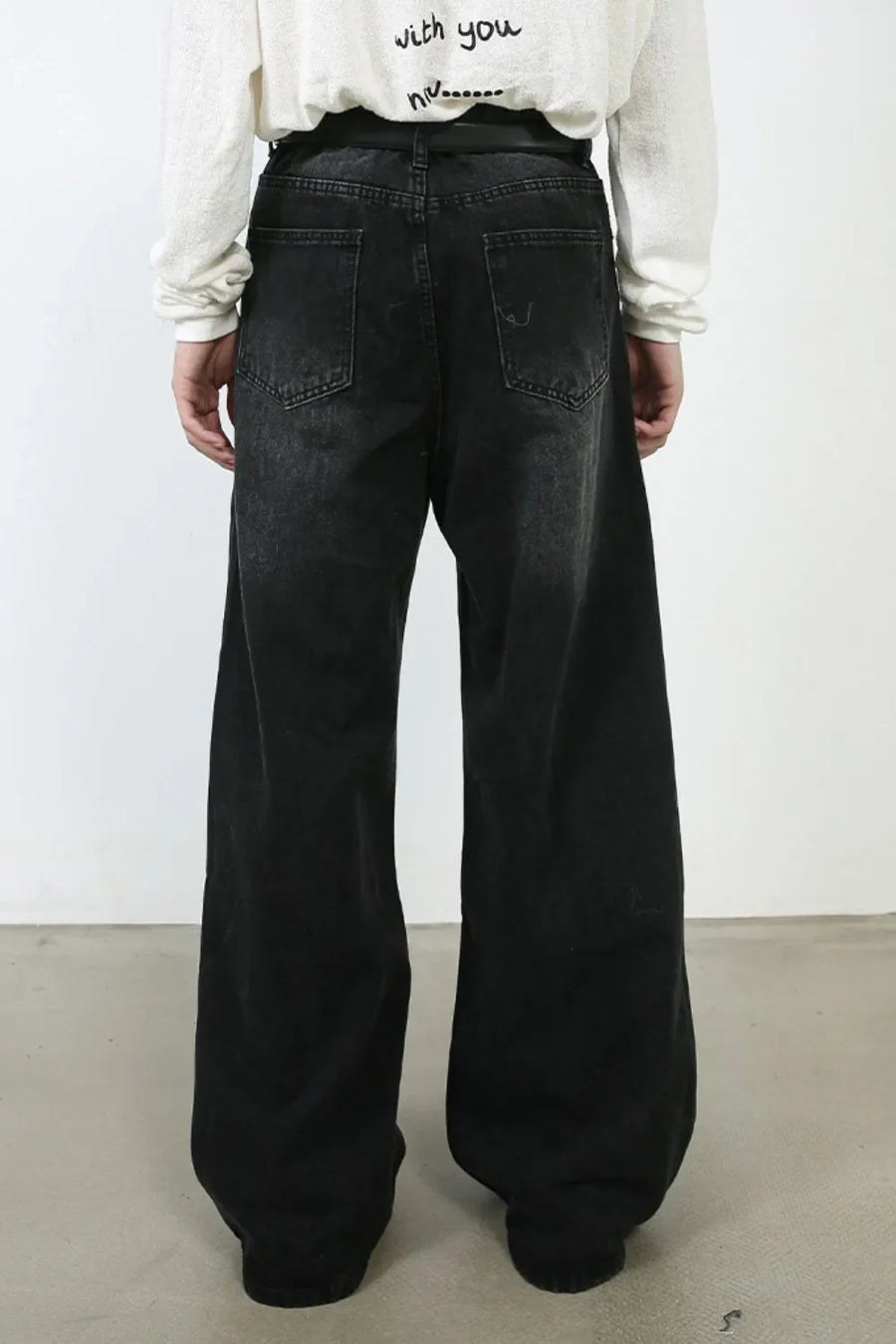 Oversized black wash denim jeans with a wide leg and distressed details.
