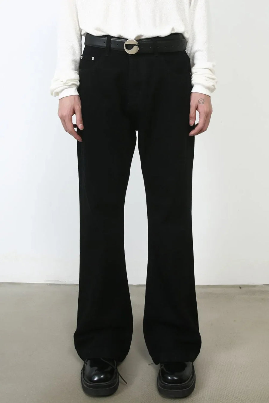 Black bootcut denim jeans with a casual fit and a silver buckle belt.