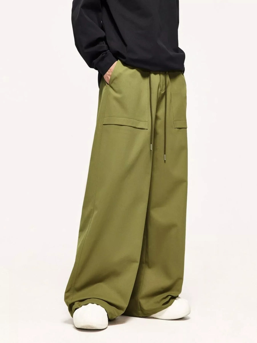Relaxed fit yellow-green cargo pants with drawstring waist and flap pockets.