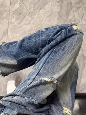 Men's baggy blue distressed jeans with ripped details and pockets.