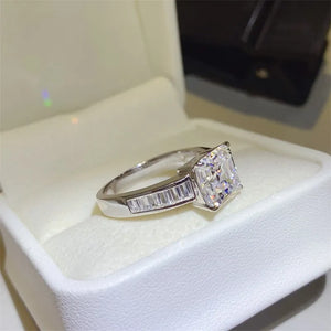 Silver ring with radiant emerald cut center stone and baguette side stones.